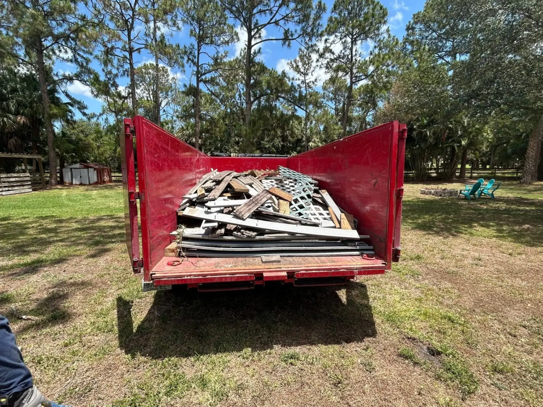 Construction debris from a deck removal project loaded into a dumpster in Palm Beach County, FL.